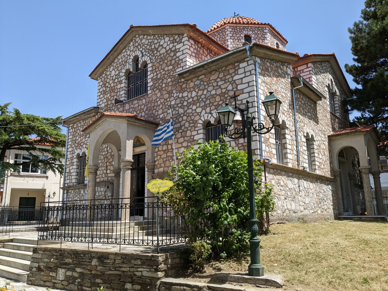 Front of the village stone church in Livadi with the Greek flag